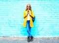 Fashion smiling woman with a smartphone on blue brick