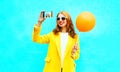 Fashion smiling woman takes a picture self portrait on smartphone Royalty Free Stock Photo