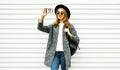 Fashion smiling woman taking selfie by smartphone in gray coat