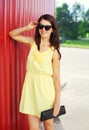 Fashion smiling woman wearing yellow dress and sunglasses with handbag clutch Royalty Free Stock Photo