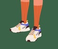 Fashion sneakers and long socks on women feet. Modern trendy sport shoes, girls athletic footwear on female legs Royalty Free Stock Photo