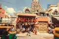 Fashion store and people walking past hindu temple on asian city street