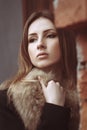 Fashion street portrait of a beautiful woman in fur coat