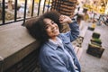 Fashion street style portrait of attractive young natural beauty African American woman with afro hair in blue coat Royalty Free Stock Photo