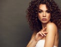 Fashion studio portrait of beautiful smiling woman with afro curls hairstyle. Fashion and beauty. Royalty Free Stock Photo