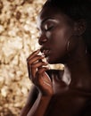 Fashion studio portrait of an extraordinary beautiful african american model with closed eyes over golden background Royalty Free Stock Photo