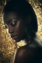 Fashion studio portrait of an extraordinary beautiful african american model with closed eyes over golden background Royalty Free Stock Photo