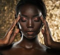 Fashion studio portrait of an extraordinary beautiful african american model with closed eyes over golden background Royalty Free Stock Photo