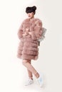 Fashion studio teen look style in pink fur coat advertise backpack and shoes. Fashionable student girl wears leather Royalty Free Stock Photo