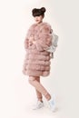 Fashion studio teen look style in pink fur coat advertise backpack and shoes. Fashionable student girl wears leather Royalty Free Stock Photo