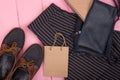 fashion stuff - bag, trousers, shoes, gift bag, note pad on pink wooden background