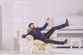 Fashion and style concept. Man with beard and mustache wearing fashionable classic suit, sits, jumps on old fashioned Royalty Free Stock Photo