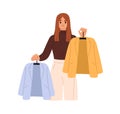 Fashion stylist helps with choice between clothes. Shop assistant consulting, offering modern garments to choose