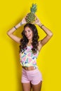 Fashion summer funny portrait indian girl with pineapple over yellow background Royalty Free Stock Photo