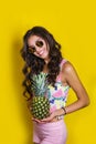 Fashion summer portrait smiling indian girl in sunglasses and pineapple over yellow background Royalty Free Stock Photo