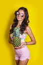 Fashion summer portrait smiling indian girl in sunglasses and pineapple over yellow background Royalty Free Stock Photo