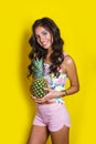 Fashion summer funny portrait indian girl with pineapple over yellow background Royalty Free Stock Photo