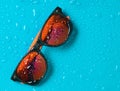 Fashion sunglasses in drops of water on a bright blue background. Royalty Free Stock Photo