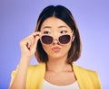 Fashion, sunglasses and a model asian woman on a purple background in studio for trendy style. Face, shades and attitude Royalty Free Stock Photo