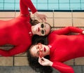 Fashion, sunglasses and swimwear of women friends in red bodysuit at indoor swimming pool. Portrait above young female Royalty Free Stock Photo