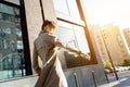 Fashion girl wear stylish trench coat walking on city street looking at camera. Royalty Free Stock Photo