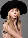 Fashion teen model in a black big hat in studio Royalty Free Stock Photo