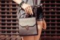 Fashion teenage woman standing in night city street in front of night club door, Stylish female model with black handbag Royalty Free Stock Photo