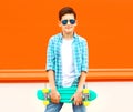 Fashion teenager boy with skateboard on colorful orange Royalty Free Stock Photo