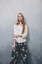 Fashion teenager girl standing against blue textured grunge wall background. Royalty Free Stock Photo