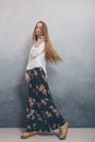 Fashion teenager girl standing on floor against blue textured grunge wall background. Royalty Free Stock Photo