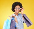 Fashion, thinking and black woman with shopping bags, smile and excited for sale in studio on yellow background. Shopper Royalty Free Stock Photo