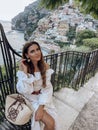 beautiful woman with dark hair in elegant clothes posing against the backdrop of the city Positano in Italy Royalty Free Stock Photo