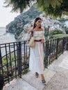 beautiful woman with dark hair in elegant clothes posing against the backdrop of the city Positano in Italy Royalty Free Stock Photo