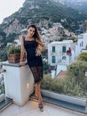 beautiful woman with dark hair in elegant clothes posing against the backdrop of the city Positano in Italy Royalty Free Stock Photo