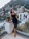 beautiful woman with dark hair in elegant clothes posing against the backdrop of the city Positano in Italy Royalty Free Stock Photo