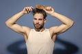 Fashion, underwear, style. Macho with bearded face and haircut in white singlet.