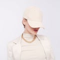 Fashion Urban Lady. Stylish Details of everyday outfit. Casual beige aesthetics.Trendy accessories velvet cap and chaine.