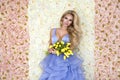 Fashion wedding dress model with a bouquet of tulips. Beautiful bride model in blue amazing wedding dress. Beauty young woman on Royalty Free Stock Photo