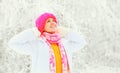 Fashion winter portrait happy woman wearing a colorful knitted hat sweater scarf over snowy background Royalty Free Stock Photo