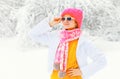 Fashion winter portrait young woman wearing a colorful knitted hat scarf over snowy Royalty Free Stock Photo