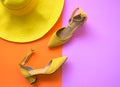 Fashion woman accessories set. Trendy fashion yellow shoes heels, stylish big hat. Colorfull orange and pink background. Royalty Free Stock Photo