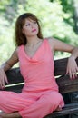 Fashion woman on the bench , with a pink piece garment