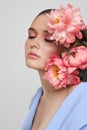 Fashion woman in blue suit with pink flowers, beauty face portrait. Art studio portrait of a young woman on a white background, Royalty Free Stock Photo