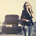 Fashion woman calling on cell phone next to broken car Royalty Free Stock Photo