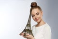 Fashion Woman With the Eiffel Tower in hand. Beautiful European model reaming of vacation in Paris. Girl love romantic city in