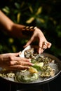 Fashion woman hands with expensive gold rings take oyster