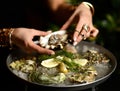 Fashion woman hands with expensive gold rings take oyster