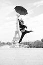 Fashion woman jump with umbrella. Happy woman travel in paris, france. Girl with beauty look at eiffel tower. Travelling Royalty Free Stock Photo