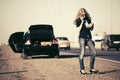 Fashion woman next to broken car calling on cell phone Royalty Free Stock Photo