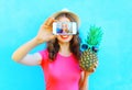 Fashion woman with pineapple taking picture self portrait on smartphone over colorful blue background screen Royalty Free Stock Photo